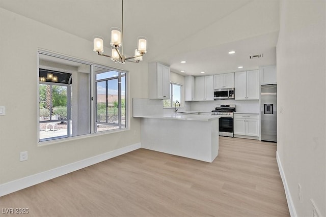 9552 Gold Bank Dr, Las Vegas, NV 89134 - kitchen featuring stainless steel appliances, a chandelier, light countertops, white cabinets, and light wood-style flooring