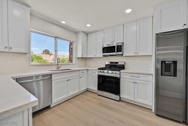 9552 Gold Bank Dr, Las Vegas, NV 89134 - kitchen featuring stainless steel appliances, white cabinets, light wood-style flooring, and recessed lighting