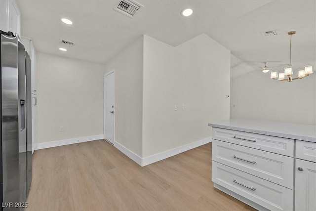 9552 Gold Bank Dr, Las Vegas, NV 89134 - kitchen with light wood-style floors, white cabinets, light countertops, stainless steel fridge with ice dispenser, and recessed lighting