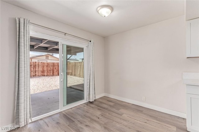 unfurnished dining area with light wood finished floors and baseboards