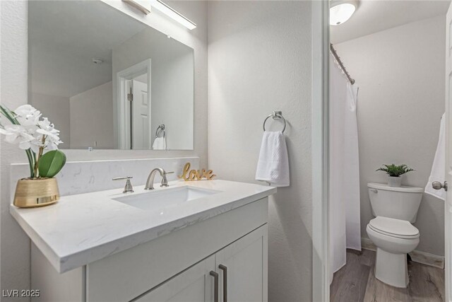 full bath with wood finished floors, vanity, and toilet