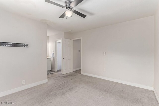 unfurnished bedroom with carpet floors, baseboards, a ceiling fan, and connected bathroom