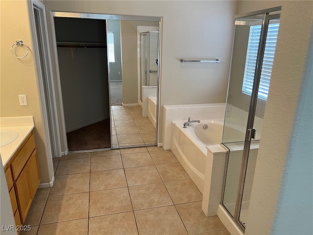 bathroom featuring a stall shower, vanity, tile patterned floors, and a garden tub