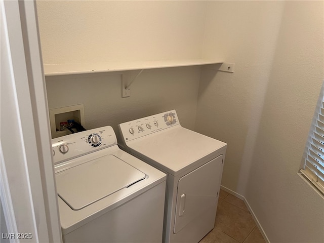 laundry room featuring washer and clothes dryer, tile patterned floors, and baseboards