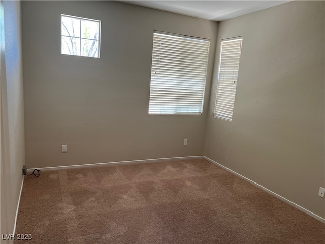 carpeted empty room featuring baseboards