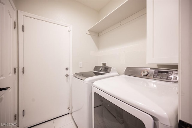 clothes washing area featuring washer and clothes dryer and light tile patterned flooring
