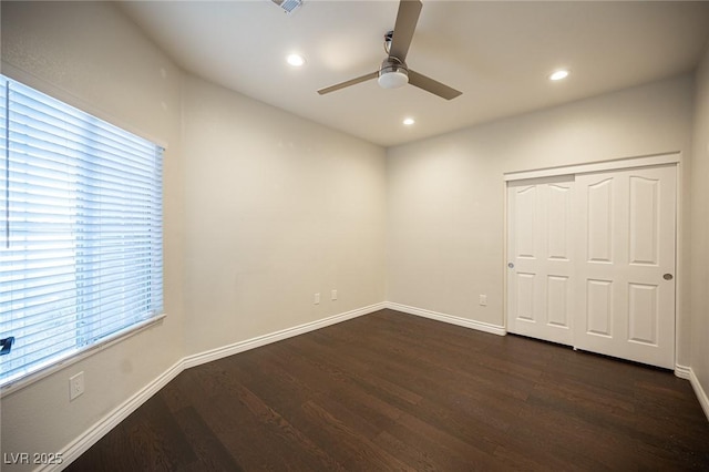unfurnished bedroom featuring dark wood-style floors, baseboards, recessed lighting, a closet, and a ceiling fan