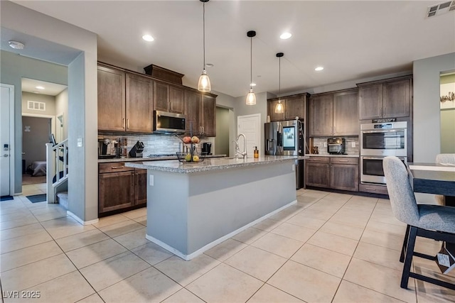 253 Kindly Way, Henderson, NV 89011 - kitchen featuring appliances with stainless steel finishes, decorative backsplash, light tile patterned flooring, dark brown cabinetry, and recessed lighting
