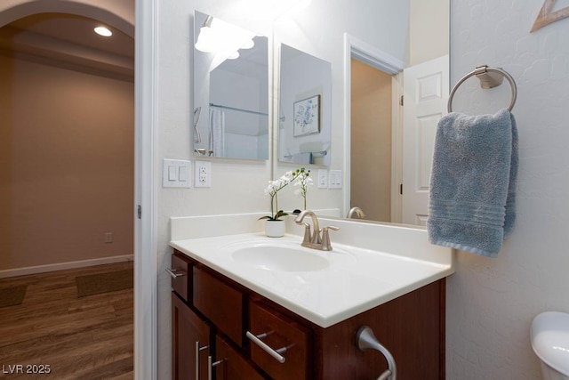 bathroom with wood finished floors, vanity, and baseboards