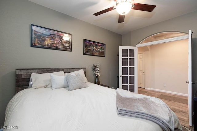 bedroom with wood finished floors, a ceiling fan, and baseboards