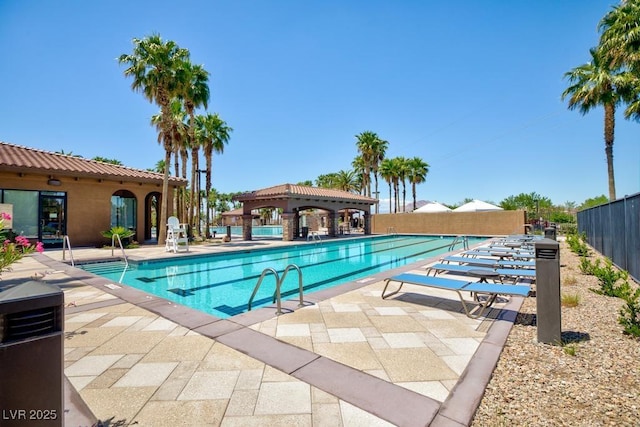 community pool with fence, a patio area, and a gazebo