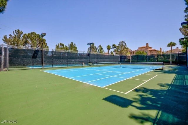 view of tennis court featuring fence