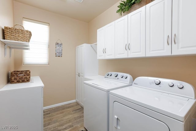 clothes washing area featuring washer and clothes dryer, cabinet space, light wood finished floors, and baseboards