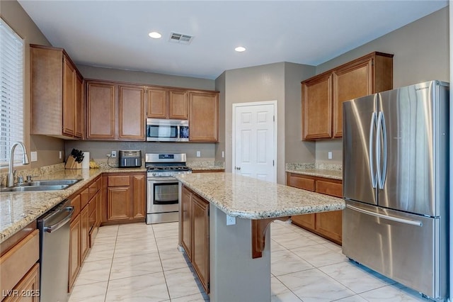 3440 Bella Viera Ct, Las Vegas, NV 89141 - kitchen with appliances with stainless steel finishes, a sink, light stone countertops, a kitchen island, and recessed lighting