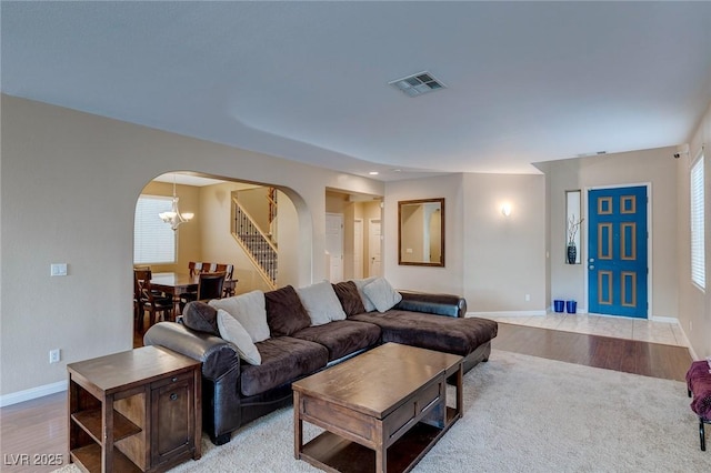 3440 Bella Viera Ct, Las Vegas, NV 89141 - living room featuring arched walkways, baseboards, a chandelier, and light wood finished floors