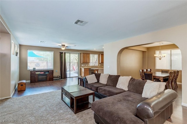 3440 Bella Viera Ct, Las Vegas, NV 89141 - living area featuring arched walkways, a chandelier, baseboards, and light wood-style flooring
