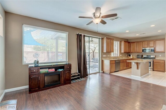 3440 Bella Viera Ct, Las Vegas, NV 89141 - kitchen with stainless steel appliances, light wood finished floors, a ceiling fan, baseboards, and recessed lighting