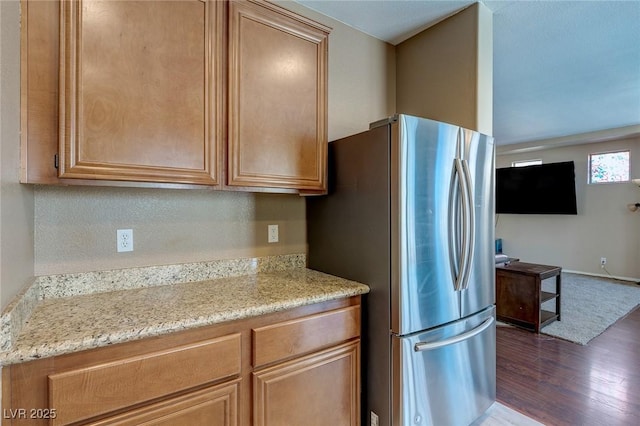 3440 Bella Viera Ct, Las Vegas, NV 89141 - kitchen with freestanding refrigerator, dark wood finished floors, light stone countertops, baseboards, and brown cabinets