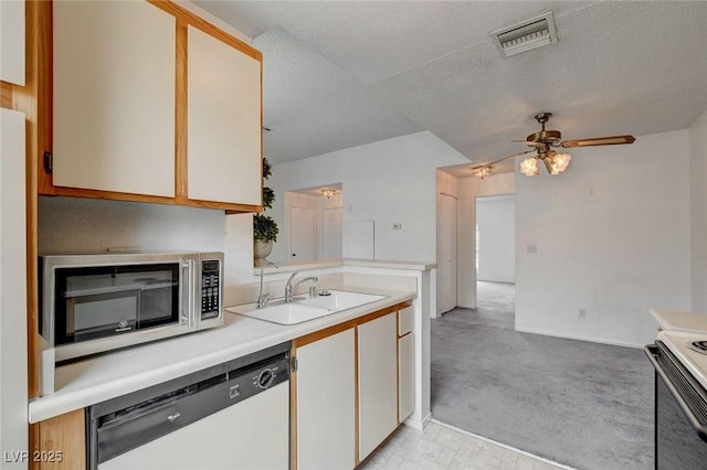 kitchen featuring dishwasher, stainless steel microwave, a sink, light countertops, and range with electric stovetop