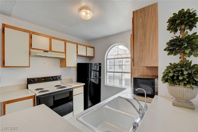 kitchen with range with electric cooktop, under cabinet range hood, freestanding refrigerator, a sink, and light countertops