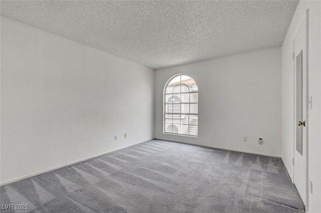 carpeted empty room featuring a textured ceiling