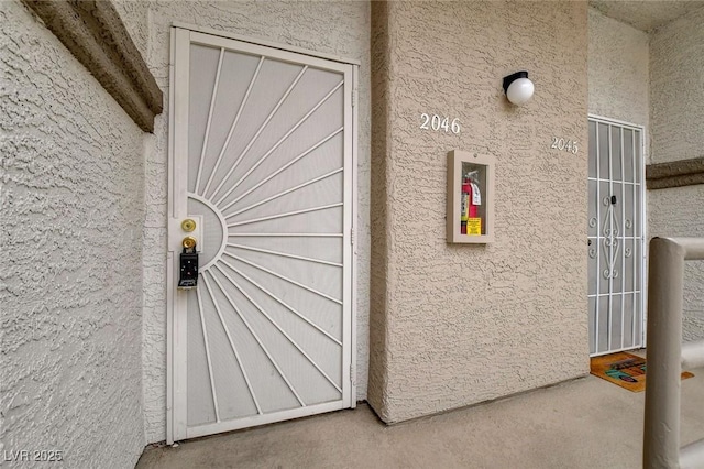 entrance to property featuring stucco siding