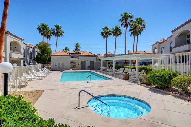 community pool featuring a hot tub, a patio, fence, and a pergola