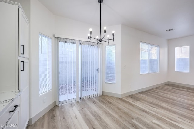 7849 Montour Falls St, Las Vegas, NV 89149 - unfurnished dining area with a chandelier, light wood-style floors, and baseboards