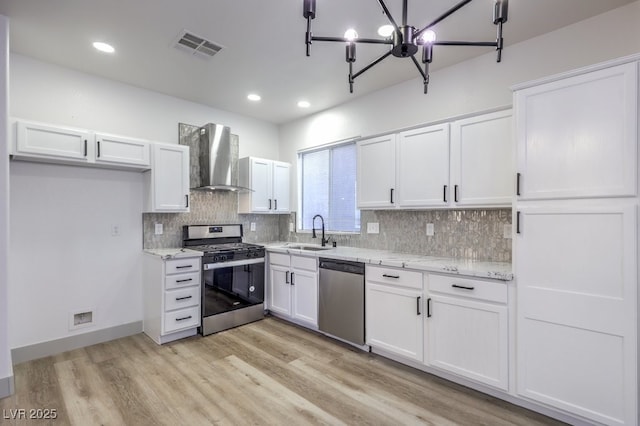 7849 Montour Falls St, Las Vegas, NV 89149 - kitchen featuring appliances with stainless steel finishes, wall chimney range hood, a sink, white cabinets, and recessed lighting