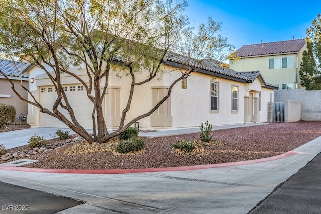 7849 Montour Falls St, Las Vegas, NV 89149 - view of home's exterior with stucco siding, a tiled roof, fence, an attached garage, and driveway