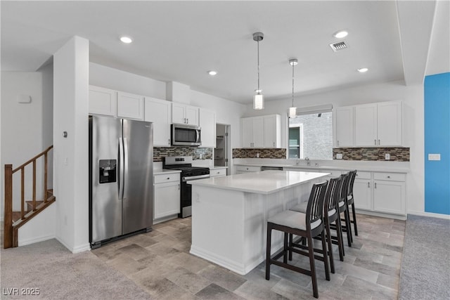 5937 W Frias Ave, Las Vegas, NV 89141 - kitchen with stainless steel appliances, white cabinets, backsplash, light countertops, and recessed lighting