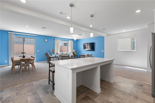 kitchen with a breakfast bar, a center island, light colored carpet, open floor plan, and recessed lighting