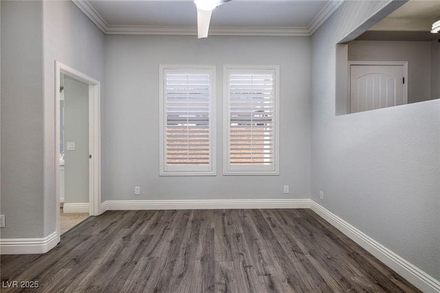 unfurnished room with dark wood-style flooring, crown molding, and baseboards