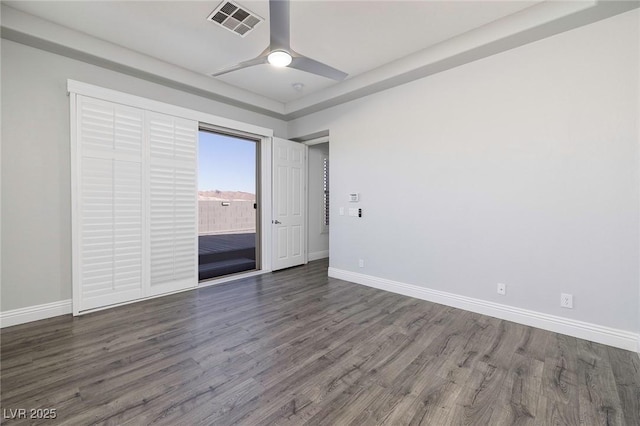 empty room featuring wood finished floors, baseboards, and ceiling fan
