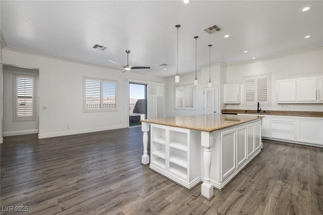 kitchen with a center island, open shelves, plenty of natural light, ornamental molding, and white cabinets