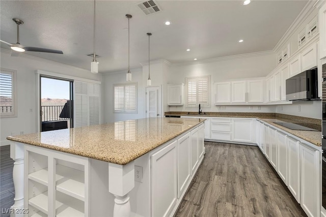 kitchen featuring a center island, white cabinetry, dark wood-type flooring, crown molding, and black electric cooktop