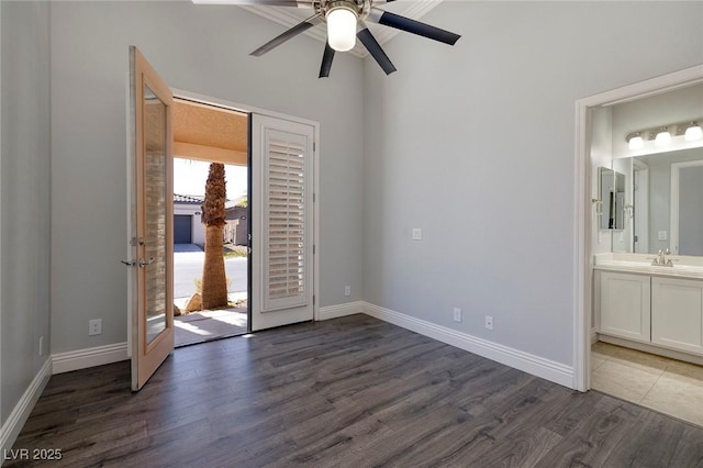 unfurnished bedroom featuring access to exterior, dark wood-style flooring, baseboards, and connected bathroom