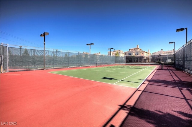 view of tennis court featuring fence