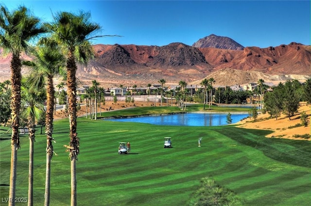 surrounding community with a water and mountain view, view of golf course, and a lawn