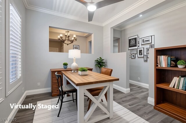 dining room with wood finished floors, healthy amount of natural light, a chandelier, and ornamental molding