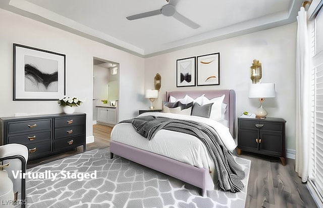bedroom with wood finished floors, connected bathroom, and a ceiling fan