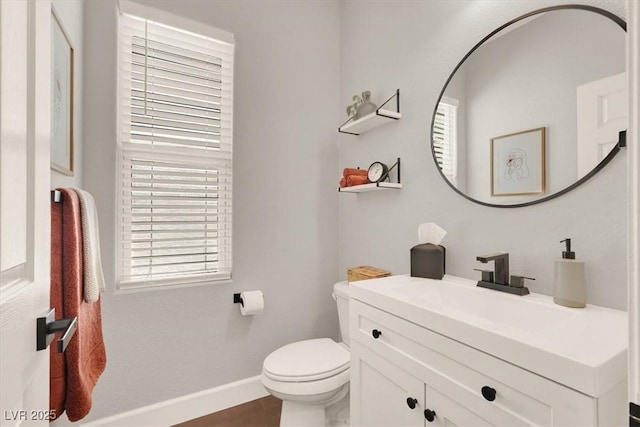 bathroom with baseboards, toilet, and vanity