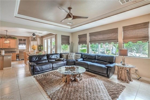 4419 Via Bianca Ave, Las Vegas, NV 89141 - living room featuring a ceiling fan, a tray ceiling, light tile patterned floors, and baseboards