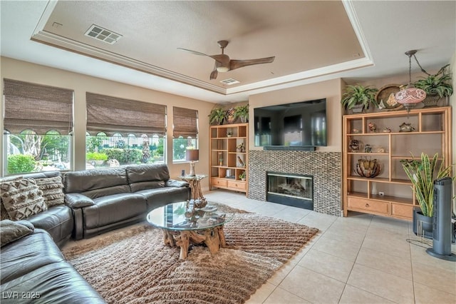 4419 Via Bianca Ave, Las Vegas, NV 89141 - living area featuring a raised ceiling, ceiling fan, tile patterned floors, and a tiled fireplace