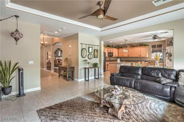 4419 Via Bianca Ave, Las Vegas, NV 89141 - living area with a ceiling fan, a raised ceiling, light tile patterned floors, arched walkways, and crown molding