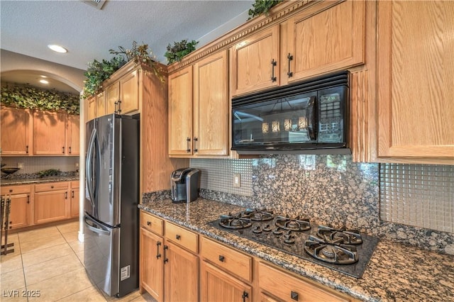 4419 Via Bianca Ave, Las Vegas, NV 89141 - kitchen with black appliances, decorative backsplash, dark stone countertops, light tile patterned floors, and a textured ceiling