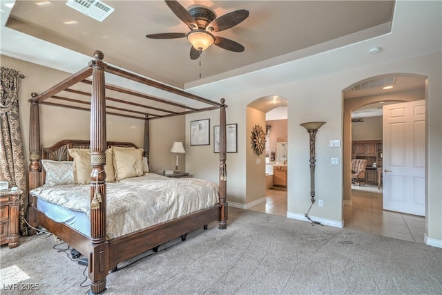 4419 Via Bianca Ave, Las Vegas, NV 89141 - tiled bedroom featuring arched walkways, carpet floors, baseboards, ensuite bathroom, and a ceiling fan