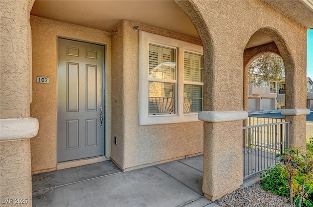property entrance featuring stucco siding and a porch