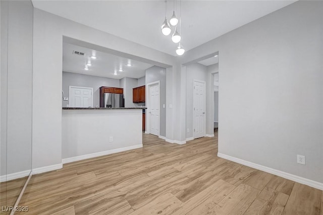 unfurnished living room featuring light wood finished floors and baseboards