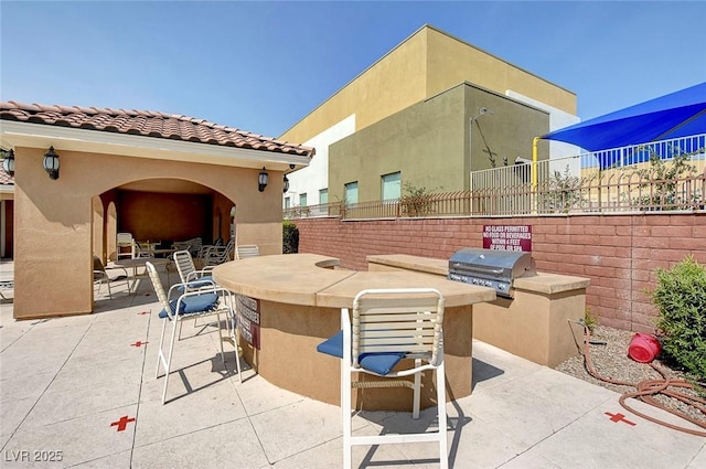 view of patio / terrace featuring an outdoor kitchen, fence, and grilling area